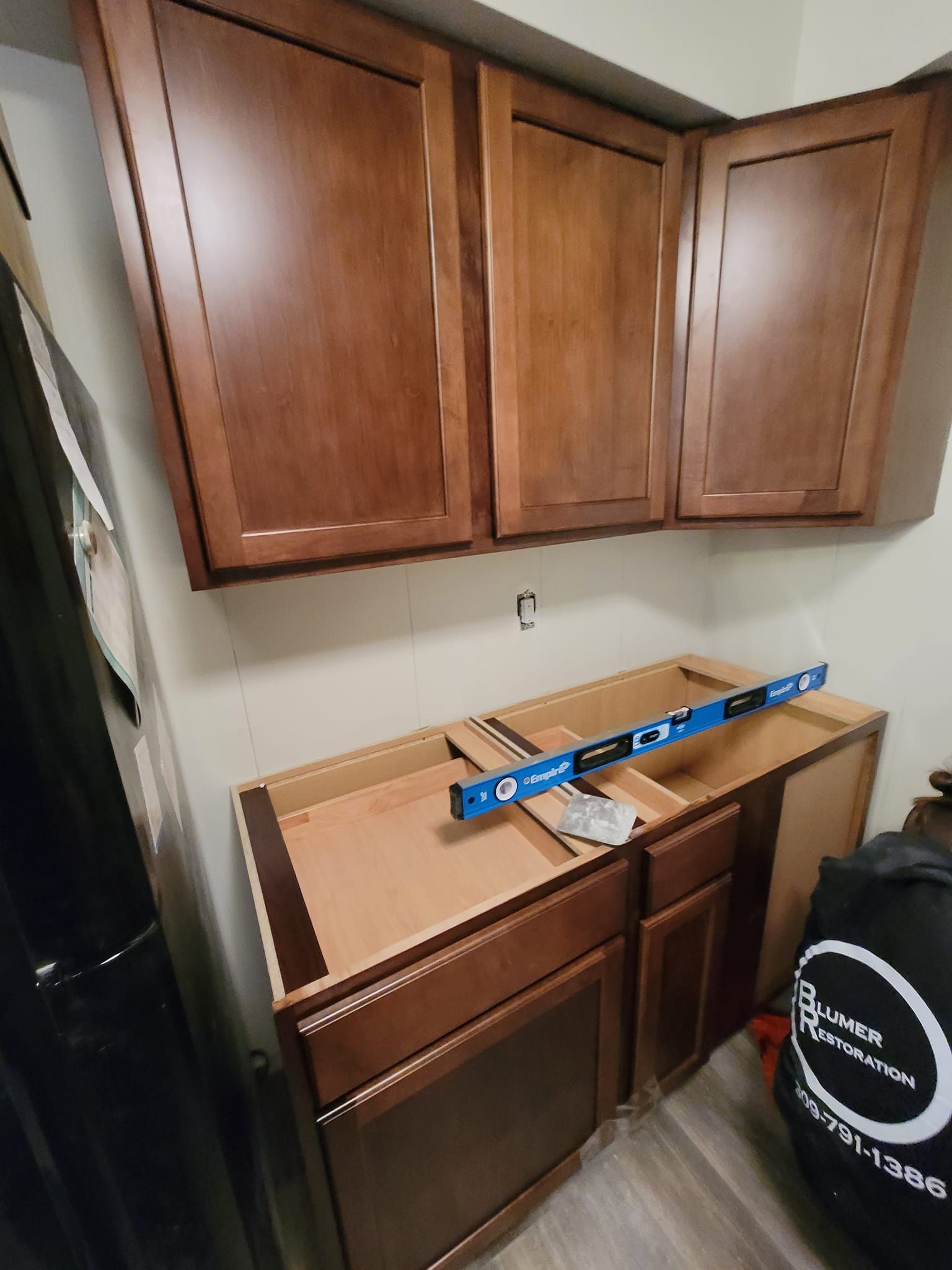 A kitchen cabinet with a blue level on top of it.