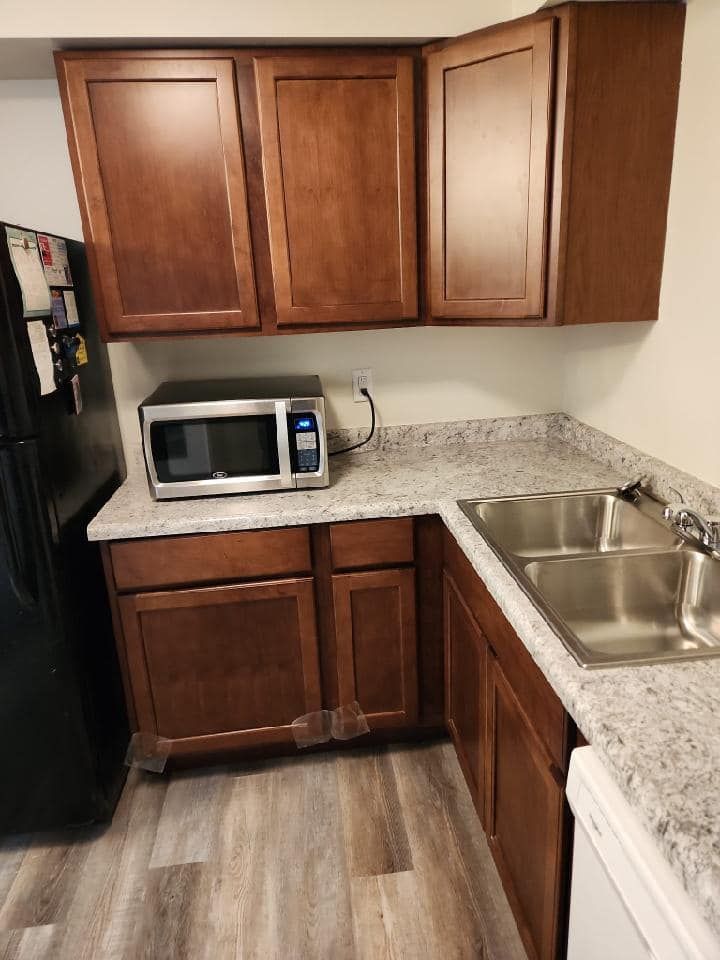A kitchen with a microwave , sink and refrigerator.
