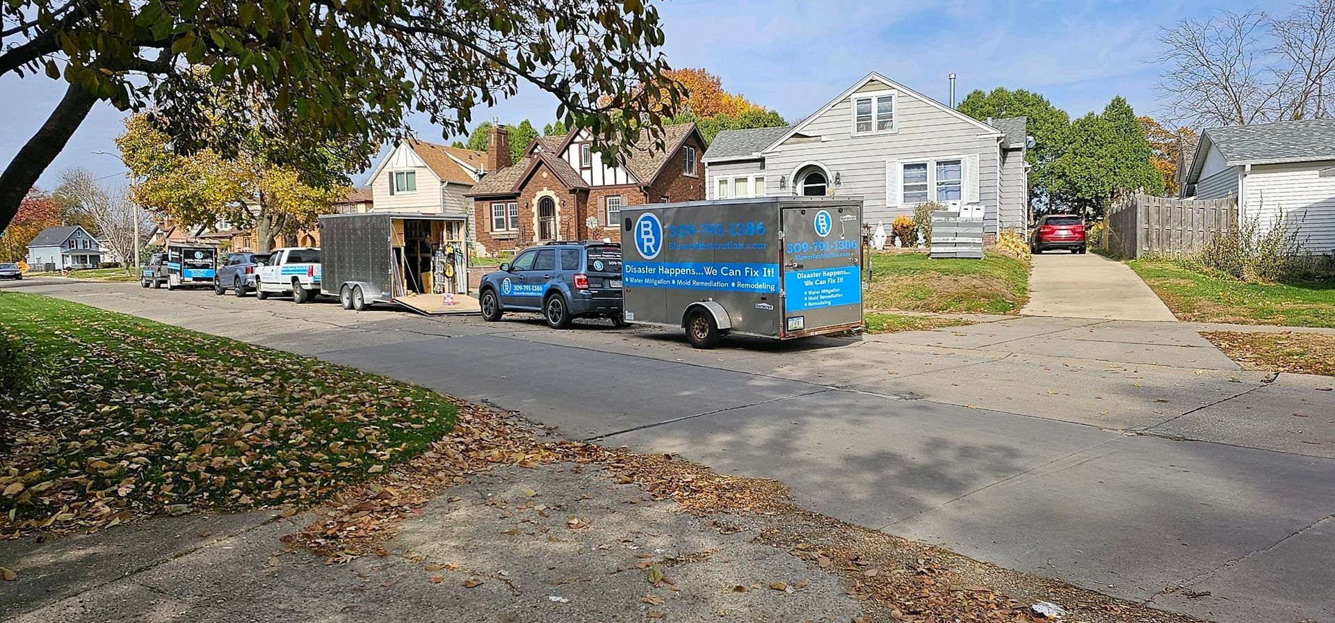 A row of cars are parked on the side of the road in a residential neighborhood.