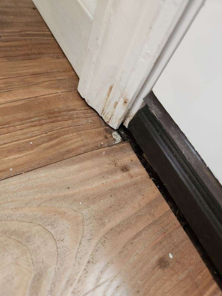 A door is sitting on a wooden floor next to a wall.