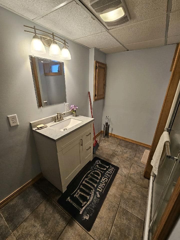 A bathroom with a sink , mirror , and rug.