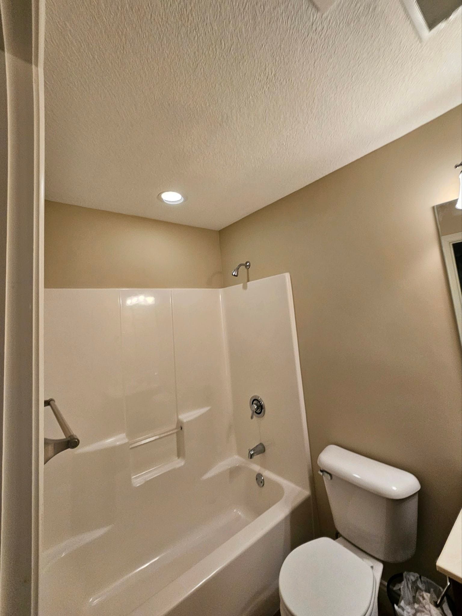 A bathroom with a tub , toilet and shower.