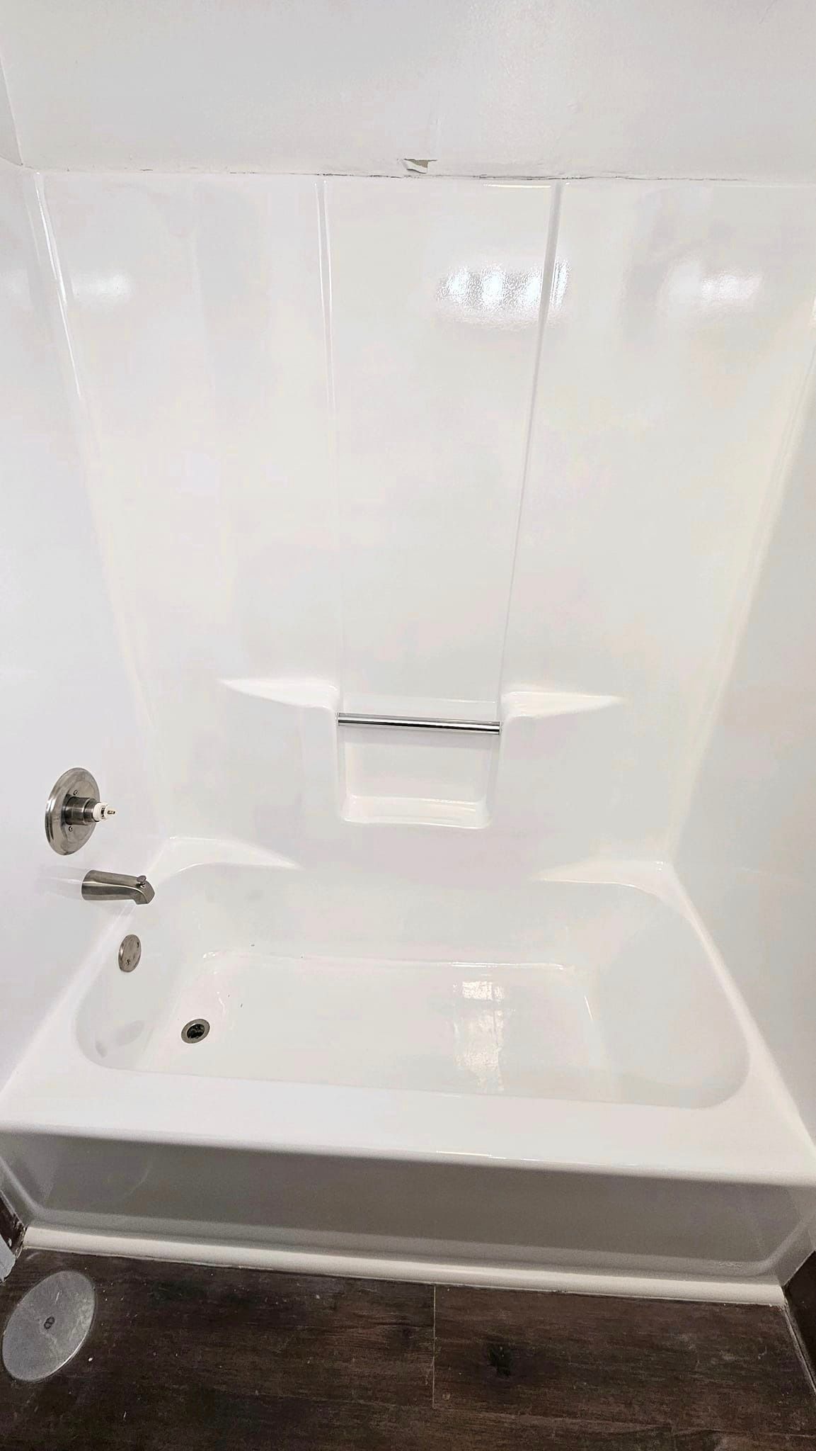 A white bathtub is sitting in a bathroom next to a shower.