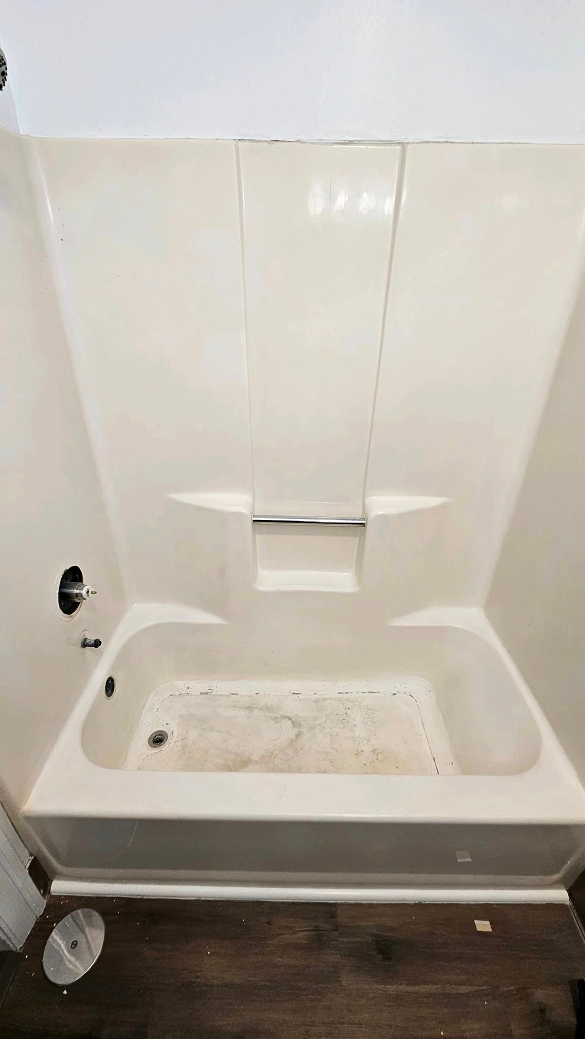 A bathtub with a shower stall attached to it in a bathroom.