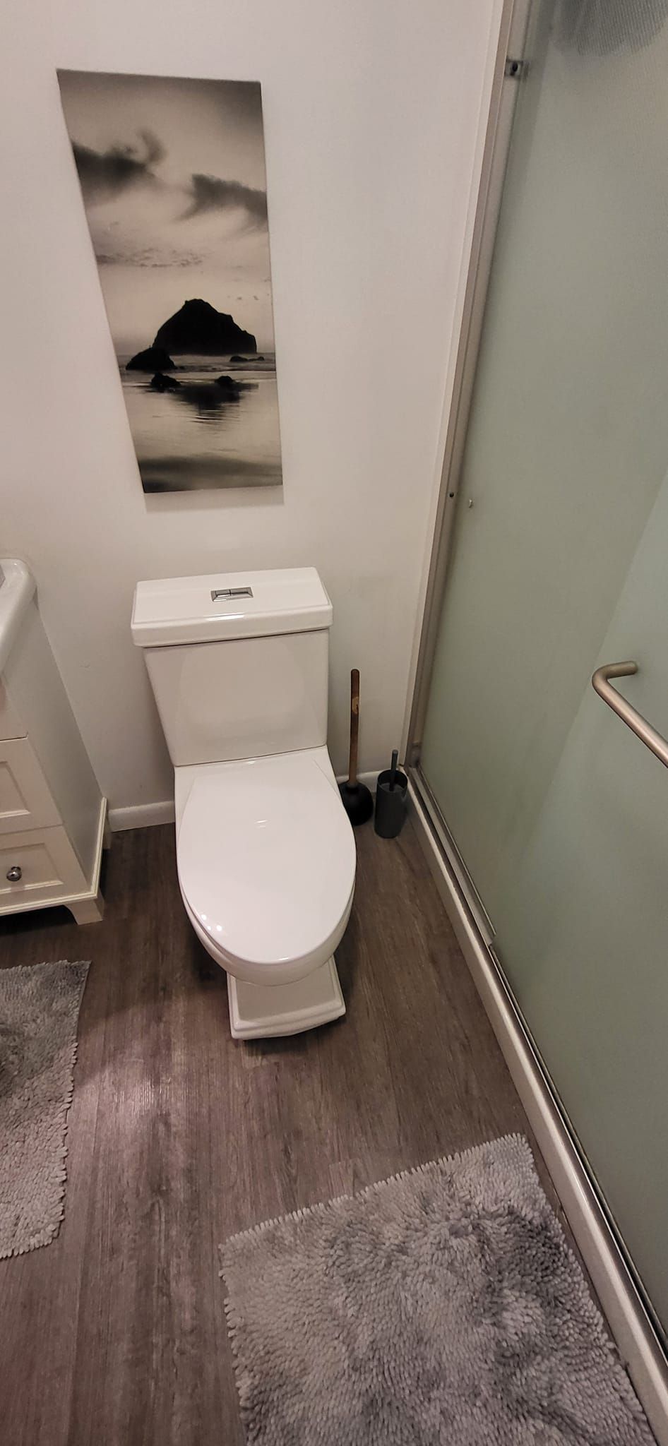 A bathroom with a toilet , sink , and shower.