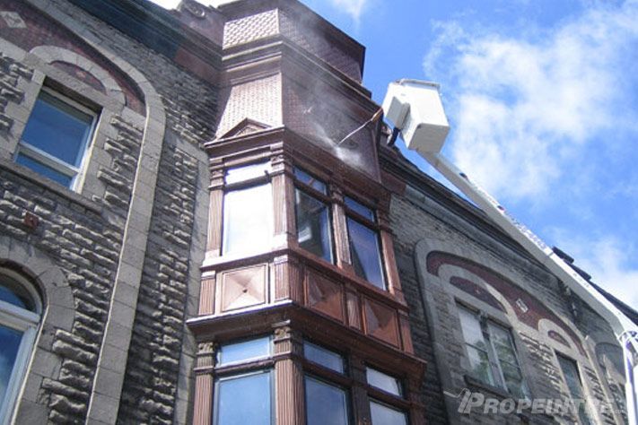 Peinture en hauteur sur bâtiment en briques avec grue, expertise professionnelle Propeintre