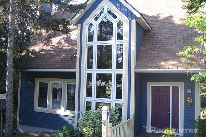 Peinture extérieure professionnelle sur grande maison avec pelouse verdoyante