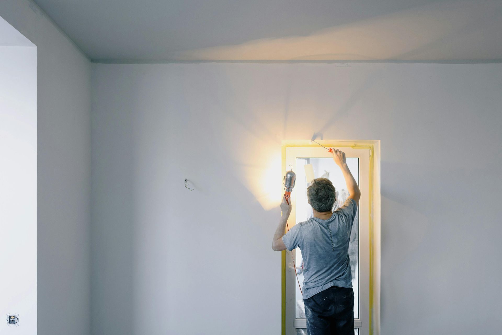 Peintre professionnel vérifiant la régularité de la surface en peignant une porte