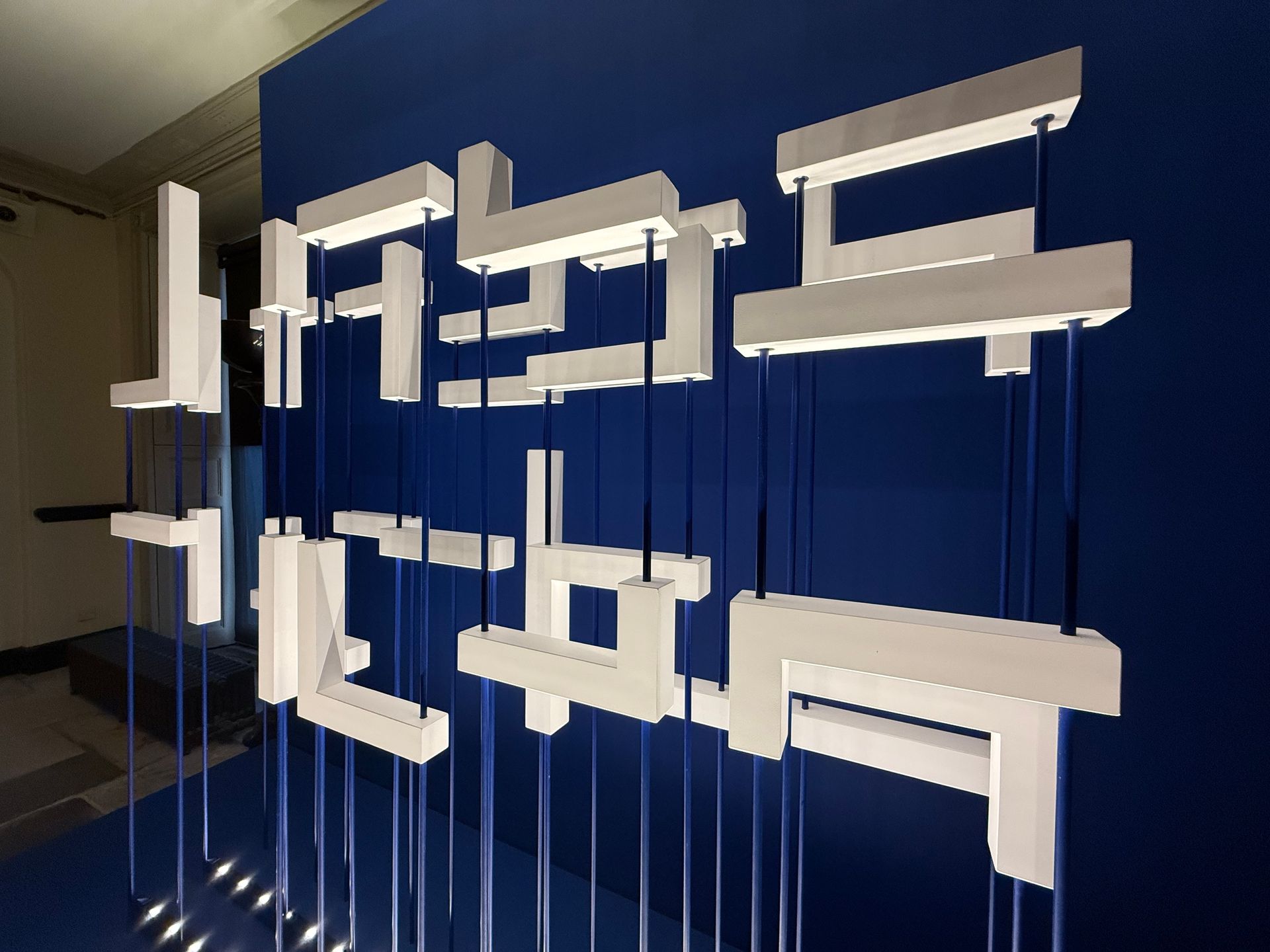 A blue wall with a bunch of white letters on it