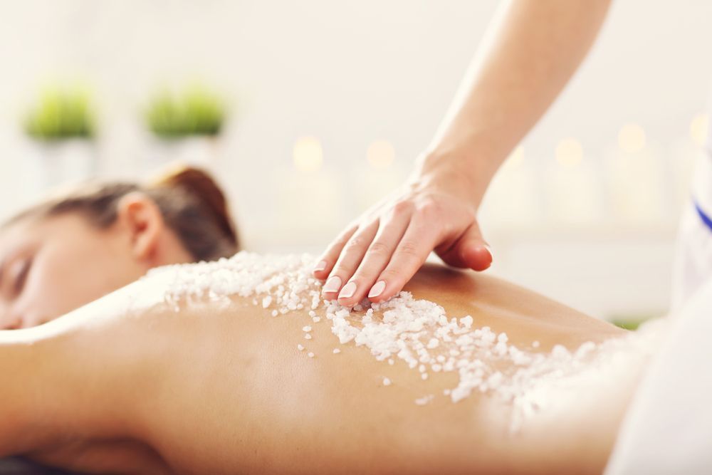 Massage Therapist Applying Scrub to Clients Back in A Spa Setting โ Figtree Day Spa in Sawtell, NSW