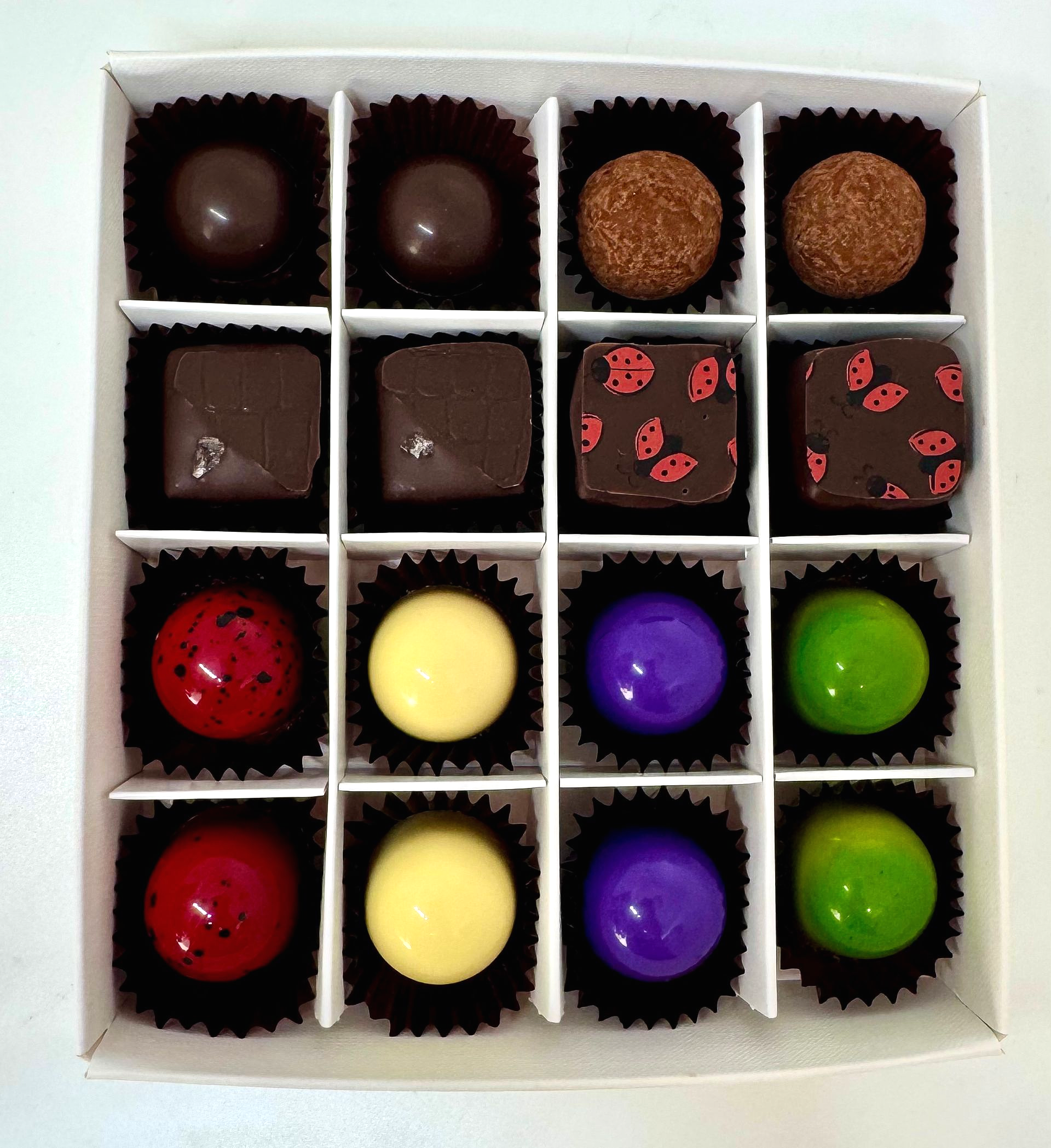 This month you will find:
Matcha & Pistachio - Matcha ganache topped with pistachio praline.
Blackcurrant & Lavender - Dark 55% chocolate shell filled with a layer dark chocolate ganache a hint of lavender, Blackcurrant gel.
Strawberry Cheesecake- Caramelised white Chocolate, sweet strawberry pate de fruit, cream cheese ganache, feuilletine biscuit base.
Lemon & Elderflower - White chocolate shell, filled with lemon curd, lemon ganache and topped with Elderflower ganache.
Raspberry Bakewell - Almond paste topped with Raspberry pate de fruit dipped in 70% Dark Valrhona chocolate - Dairy Free
Oregano & Sea Salt 65% Dark chocolate ganache infused with Oregano from my garden.
Dark Choc- Mint Truffle - Fresh mint picked from my garden combined with Dark chocolate - a well loved classic!
⭐️ Oozy Sea Salt Caramel ….. One of my Great Taste Award winners !
Posted out Monday - Thursday. Weather permitting!
Check out my socials for more photos on how I make them.