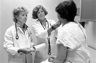 Woman Being Check by Two Doctors — Tampa, FL — Gegan Law Office Woman Being Check by Two Doctors — Tampa, FL — Gegan Law Office