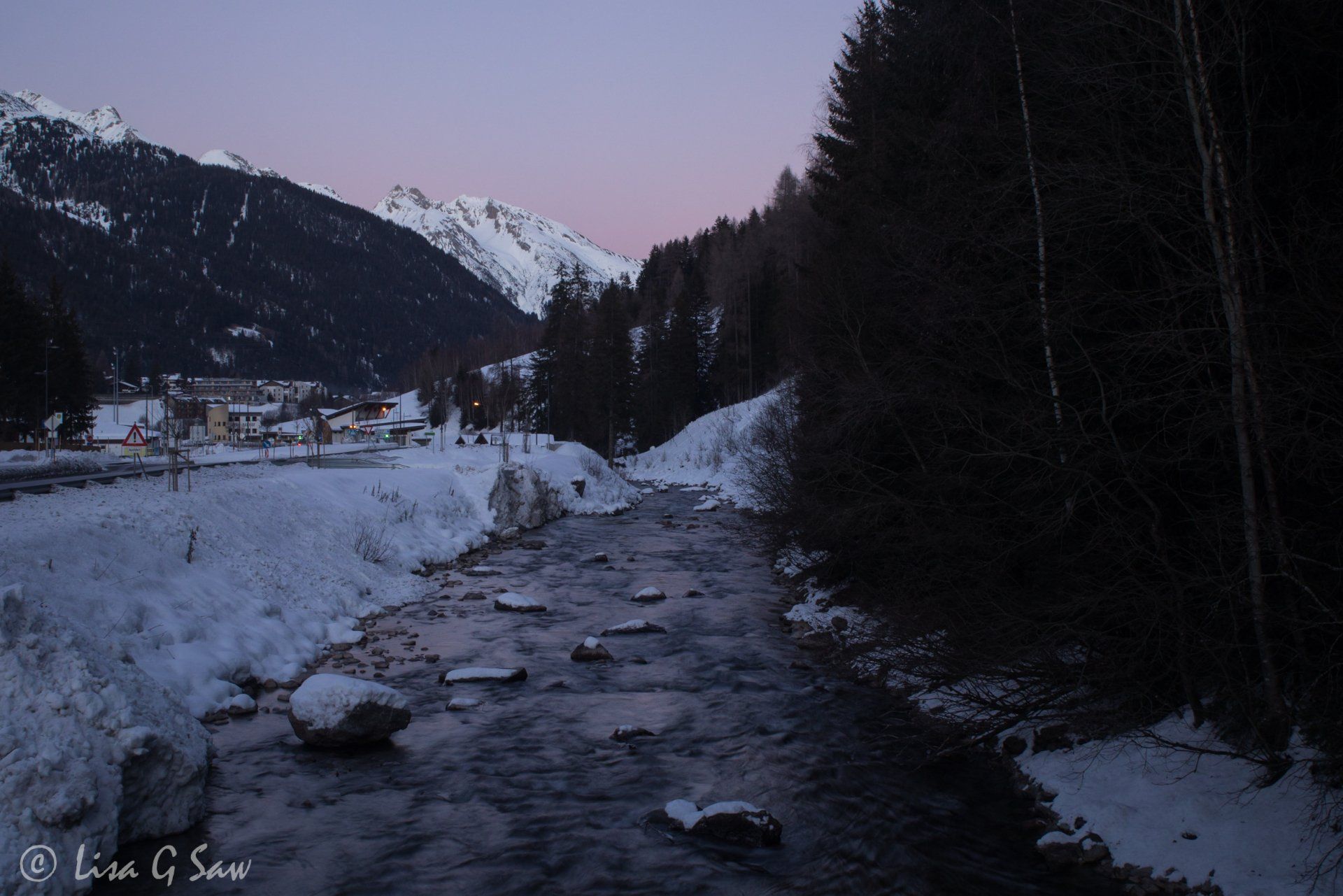 Tree-lined river alongside St Anton at dusk