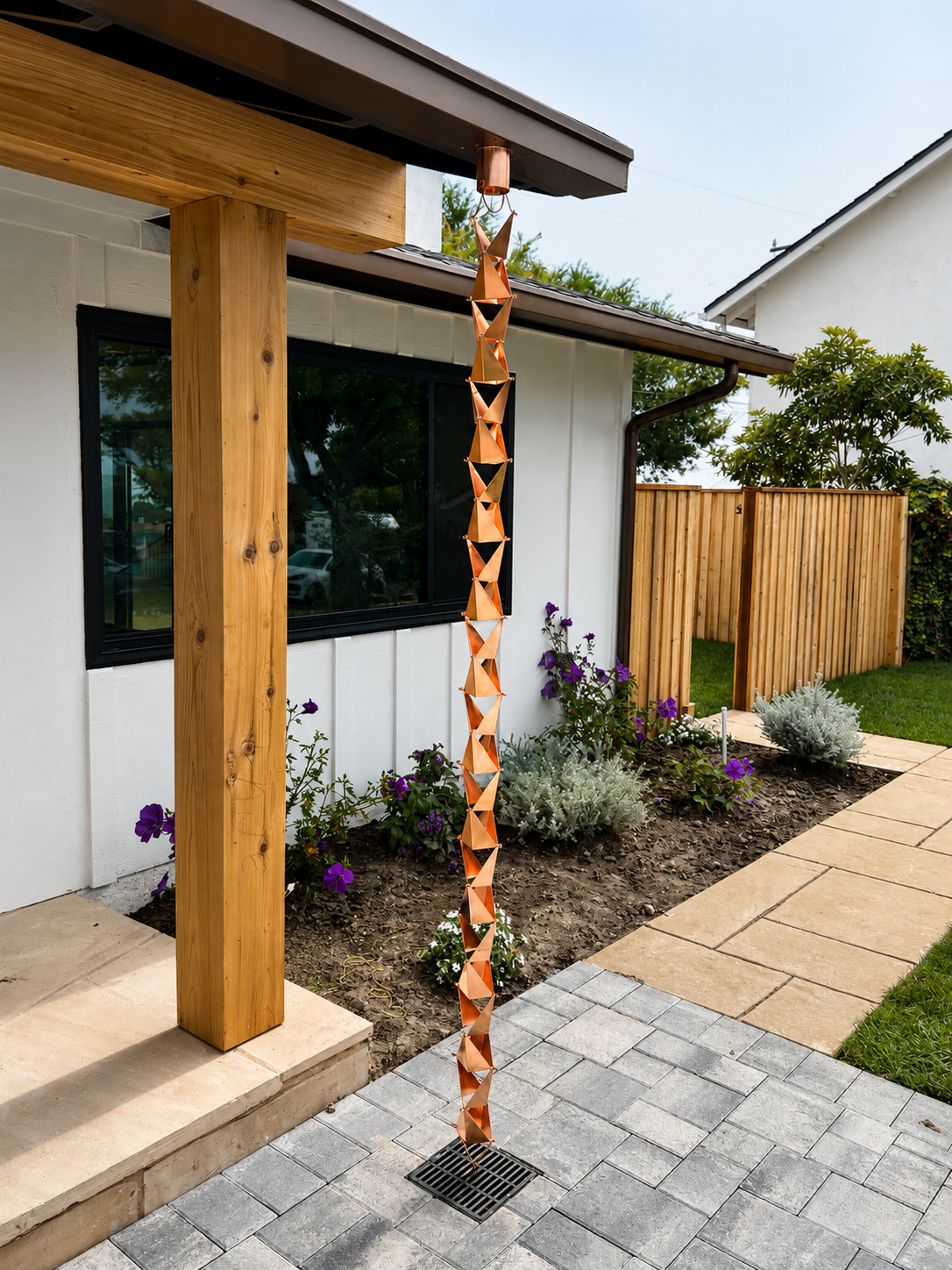 Wooden carved post beside a modern house entry with pavers and landscaped garden beds.