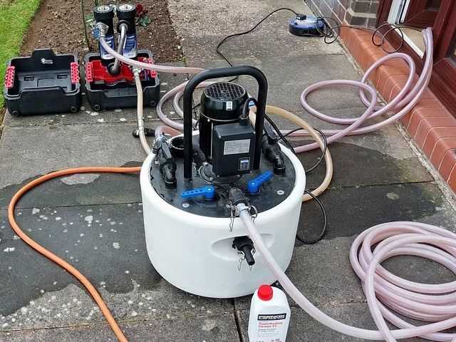 Water pump system on a paved surface with hoses, a motor, and containers.