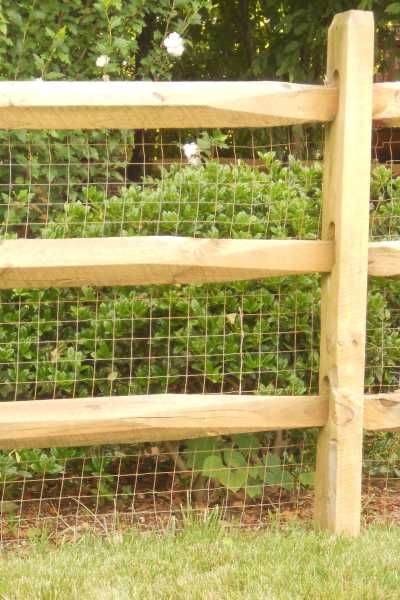 A wooden fence with a wire fence behind it