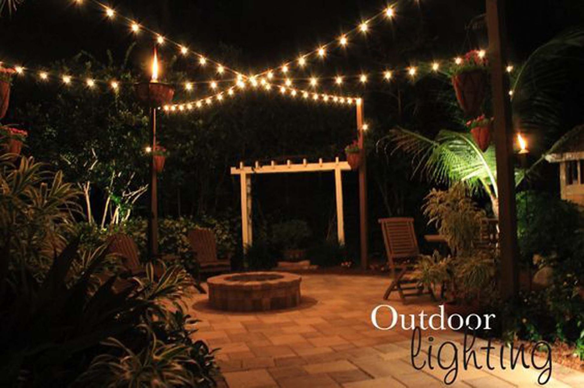 A fire pit is lit up with outdoor lighting