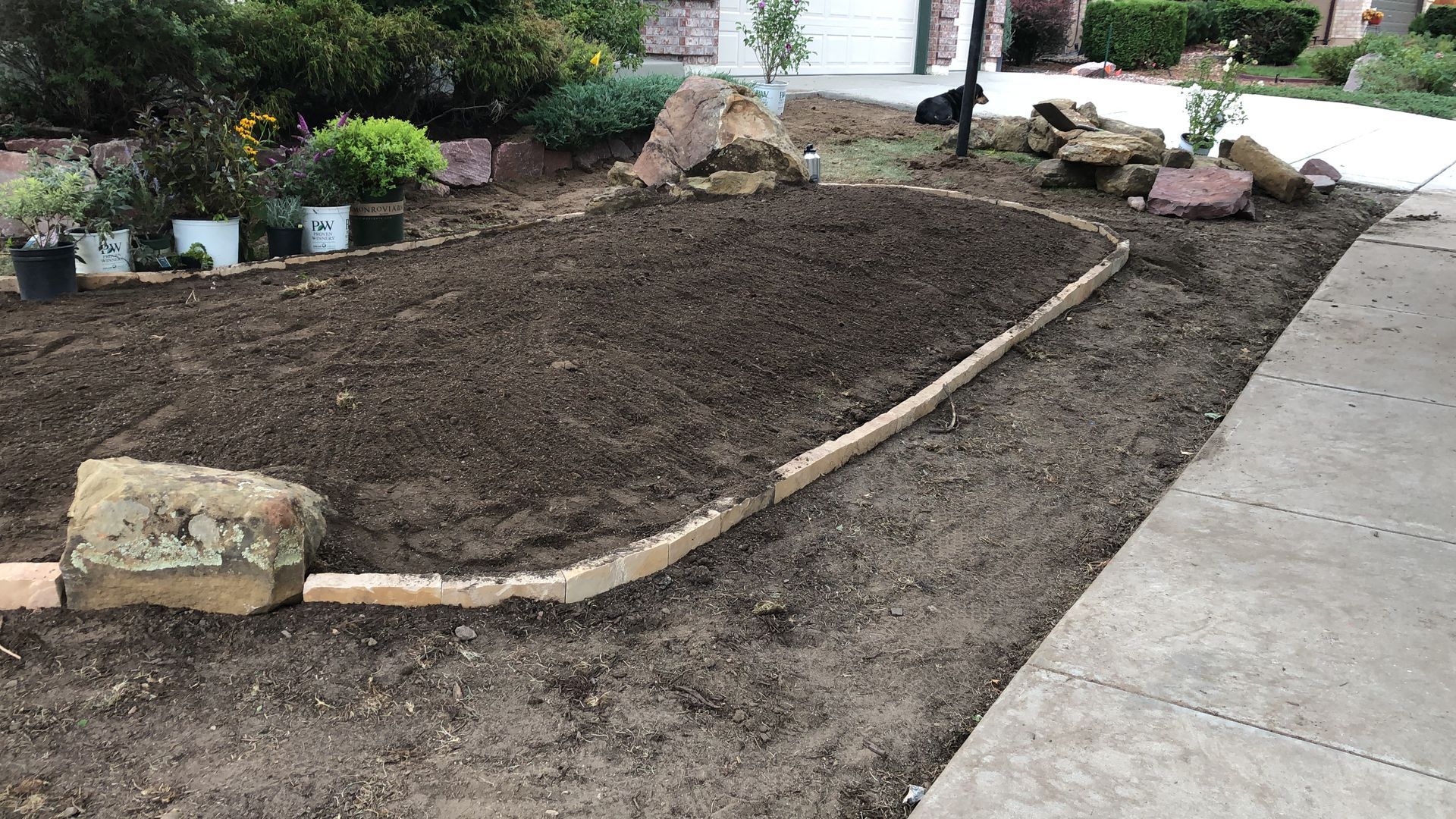 A large pile of dirt is sitting next to a sidewalk.