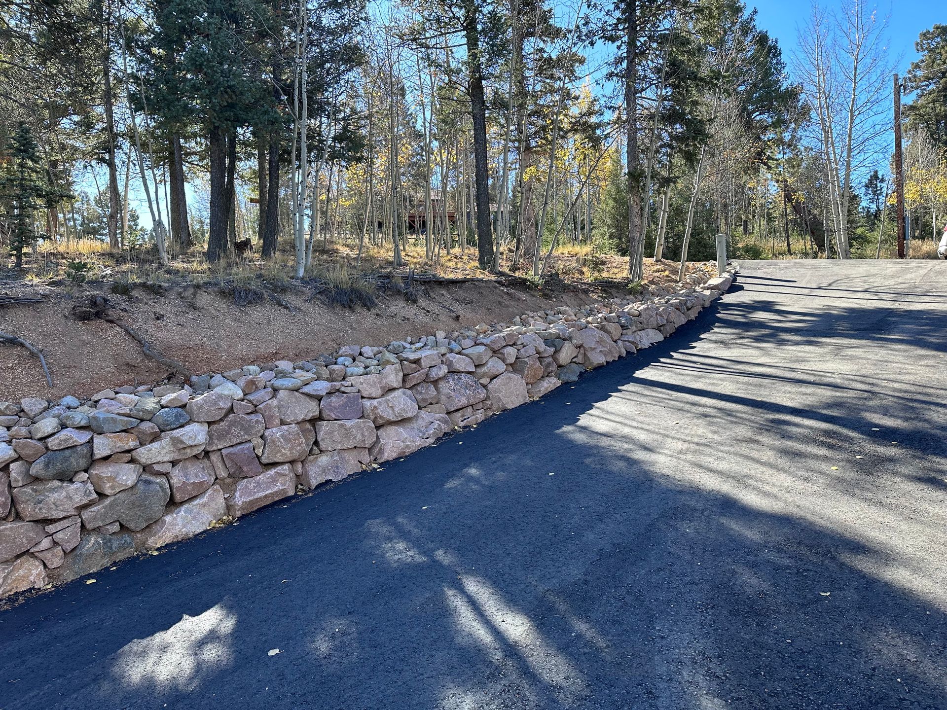 A road with a stone wall on the side of it