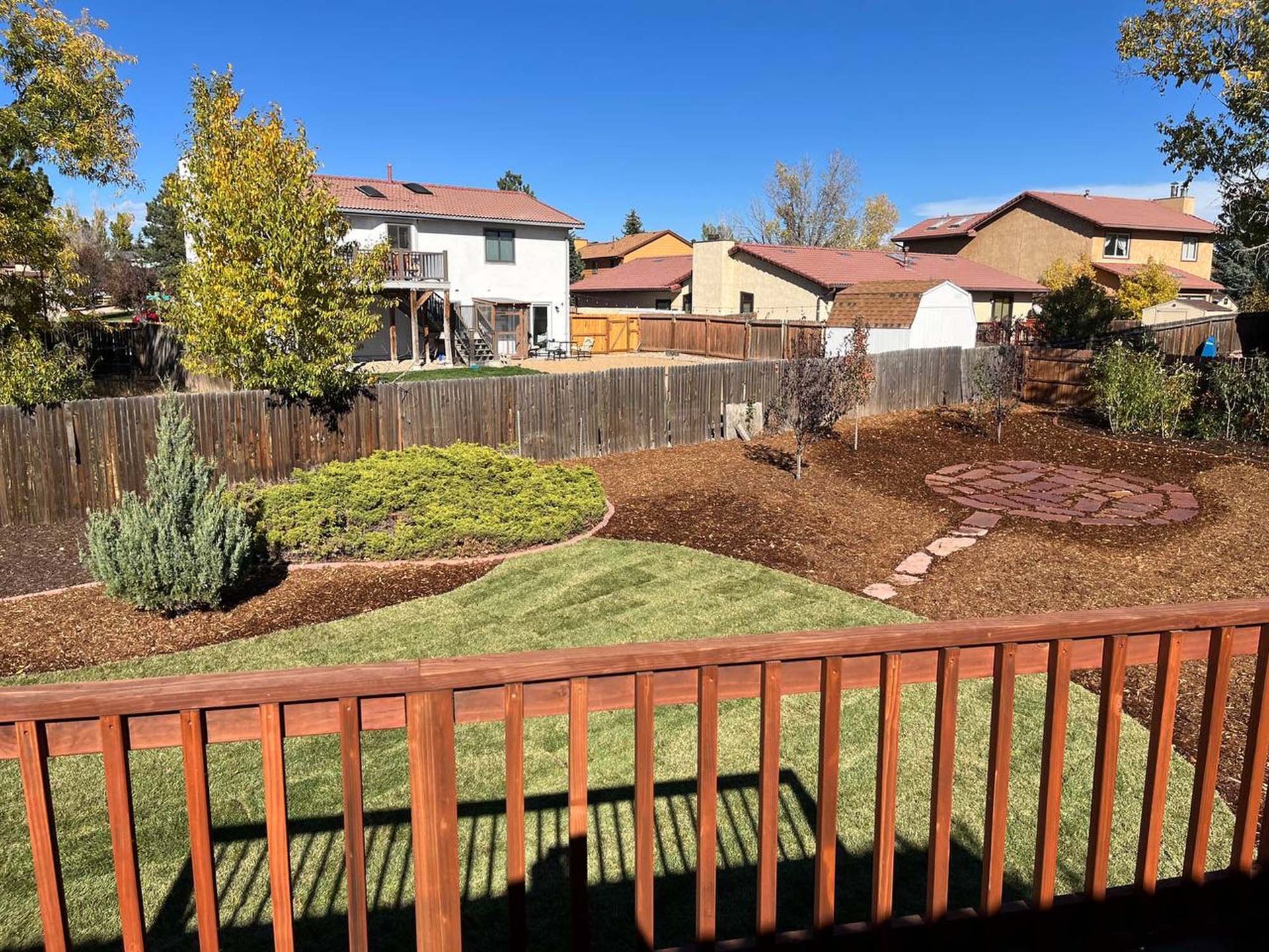 A view of a backyard from a wooden deck