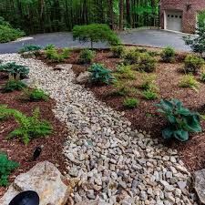 A gravel path leading to a garage in a lush green garden.