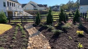 A path leading to a house with a fence in the background.