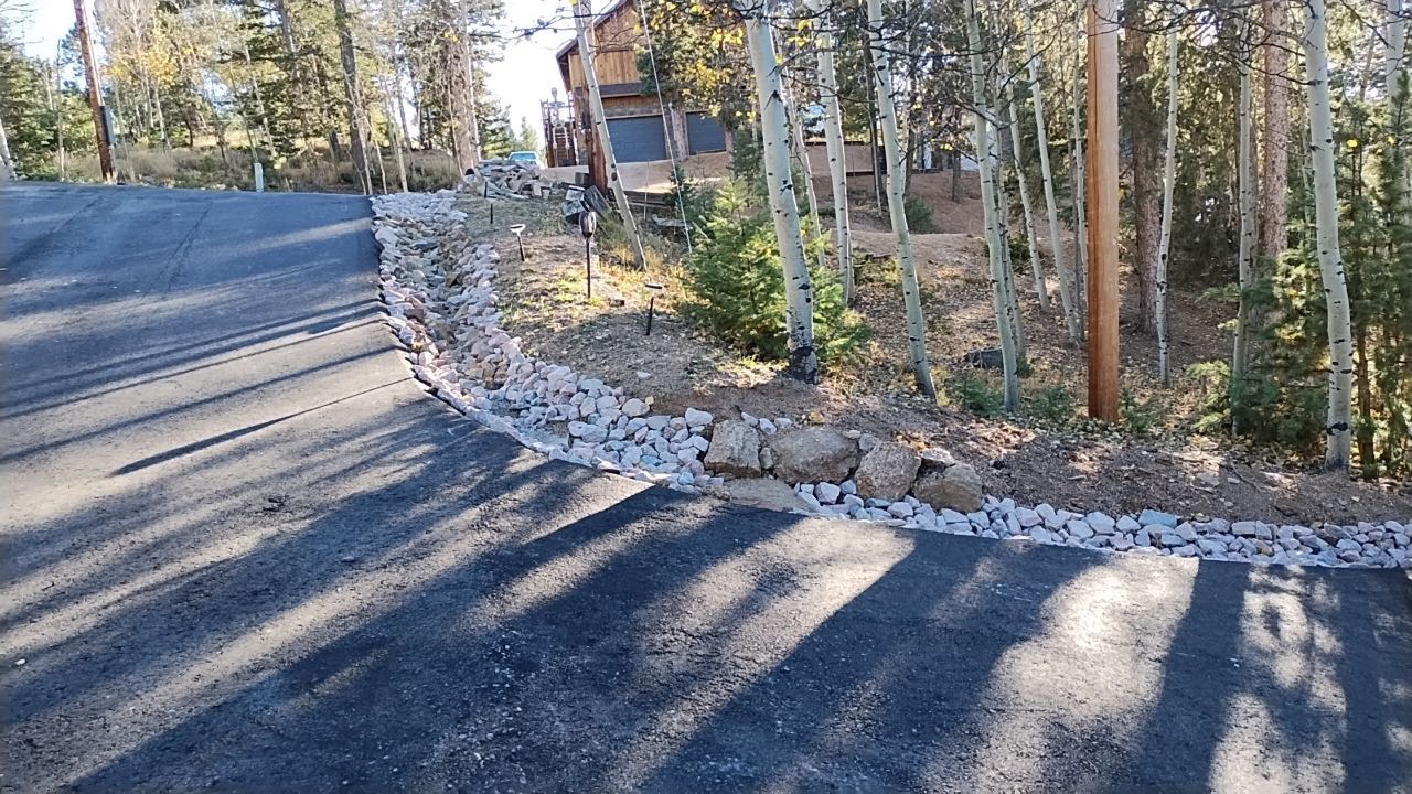 A road going through a forest with a house in the background.