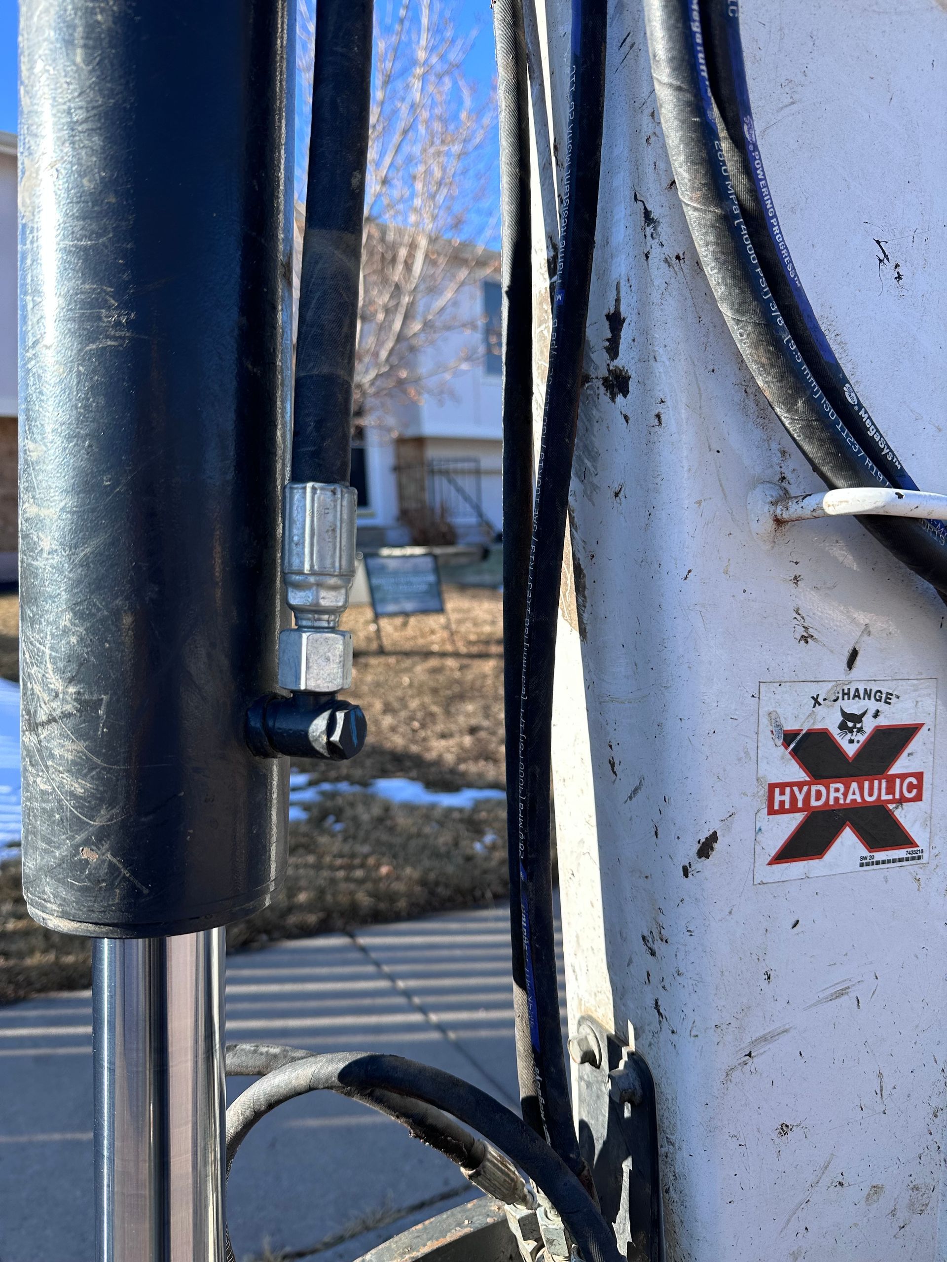 Close-up of black and white scooter handlebars with a red star logo, outdoors in sunlight.