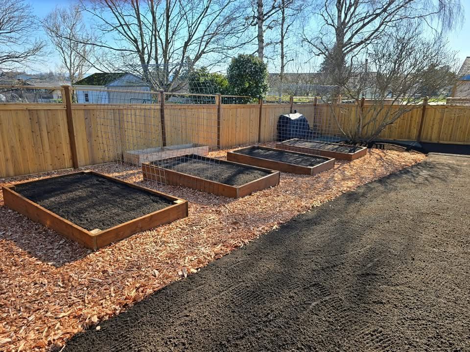 A backyard with a wooden fence and raised garden beds.