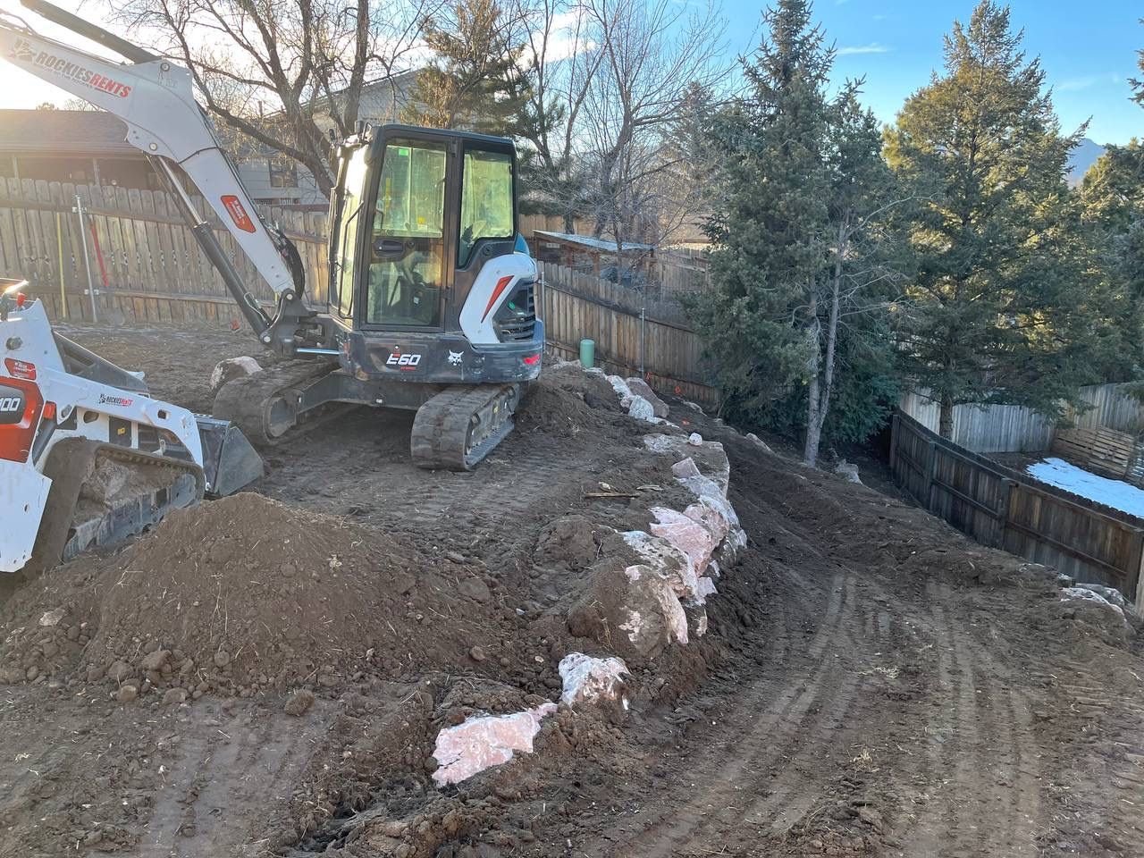 A bulldozer is sitting on top of a pile of dirt.