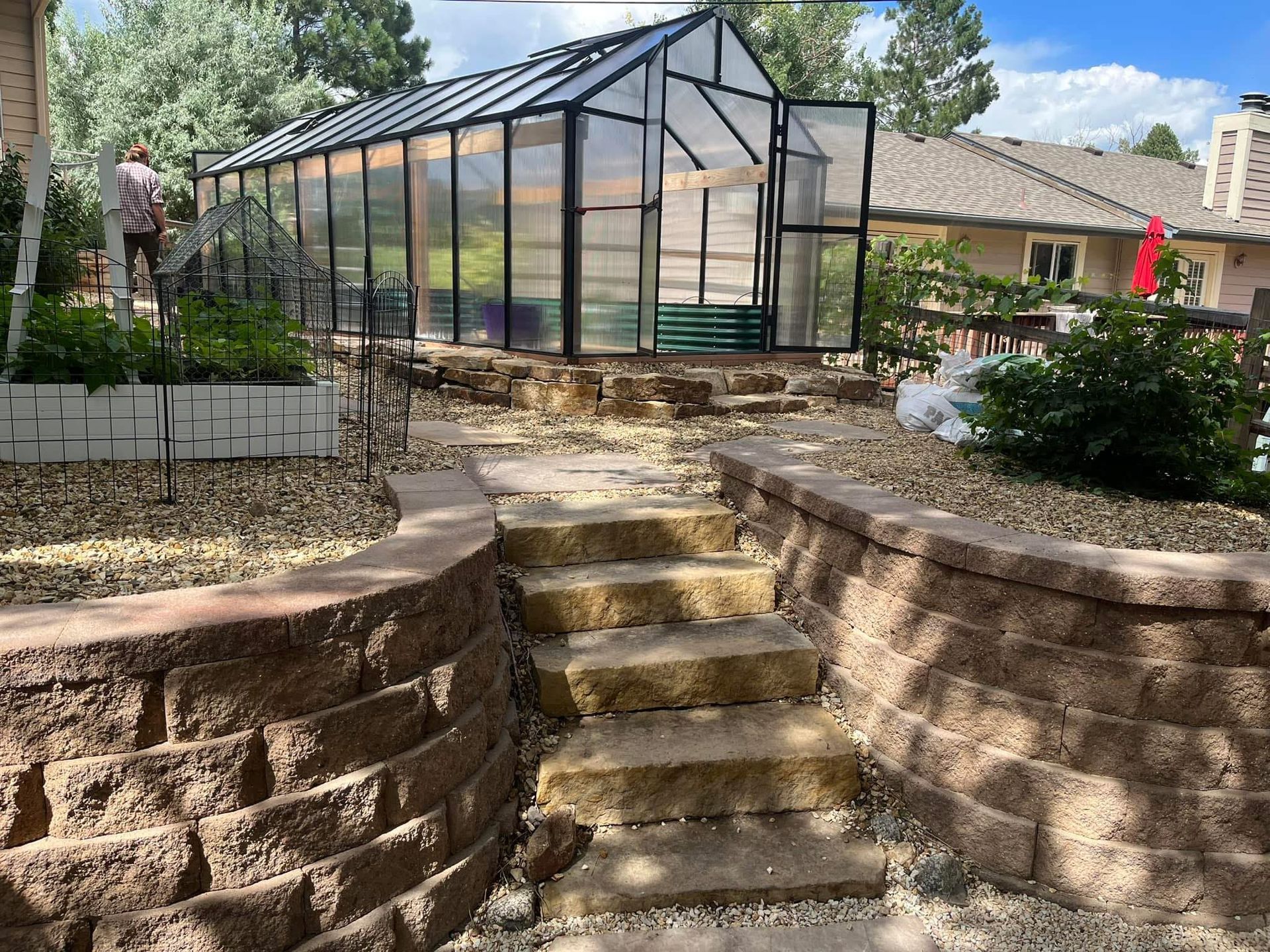 Stairs leading up to a greenhouse in a backyard