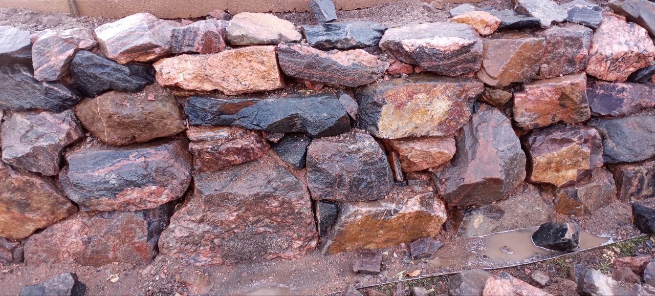 A pile of rocks sitting on top of a dirt ground.