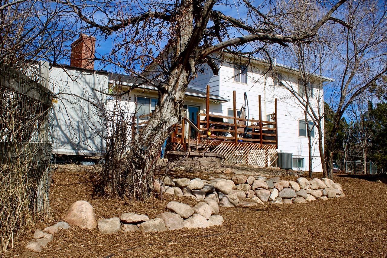 A white house with a deck and a chimney