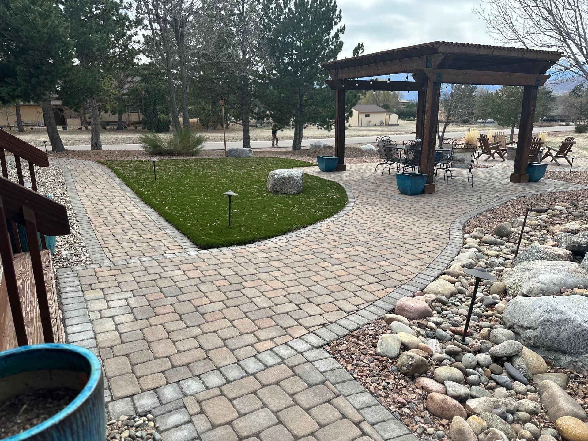 Accessible park path with gazebo, cobblestone walkway, trees, and landscaped rocks