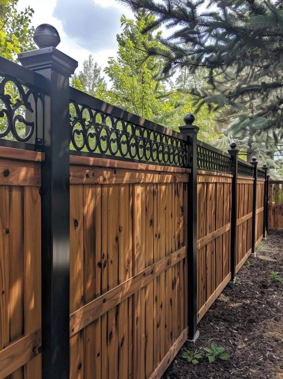 Wooden privacy fence with black metal lattice and posts along a yard path