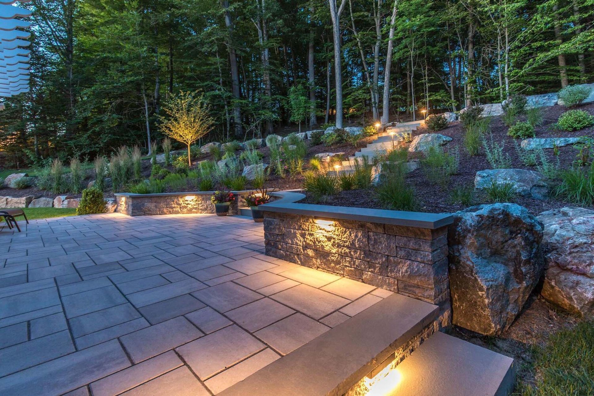 A patio with stairs leading up to it and trees in the background
