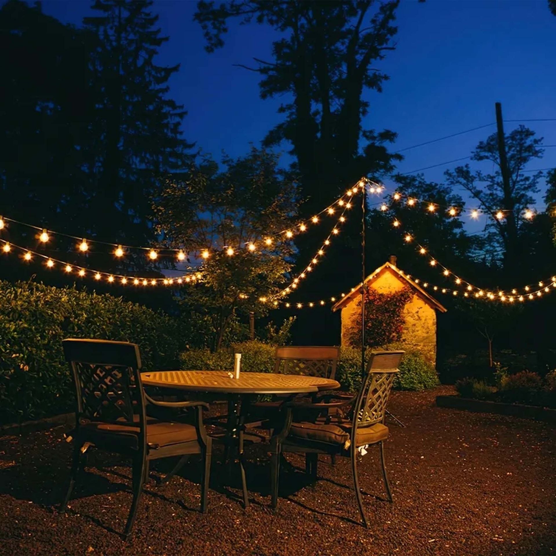 A string of lights hangs over a table and chairs