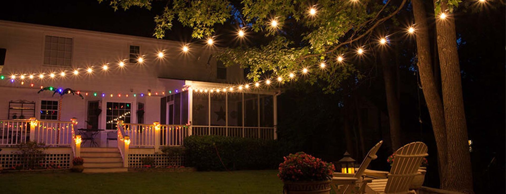 A house with a screened in porch is lit up at night