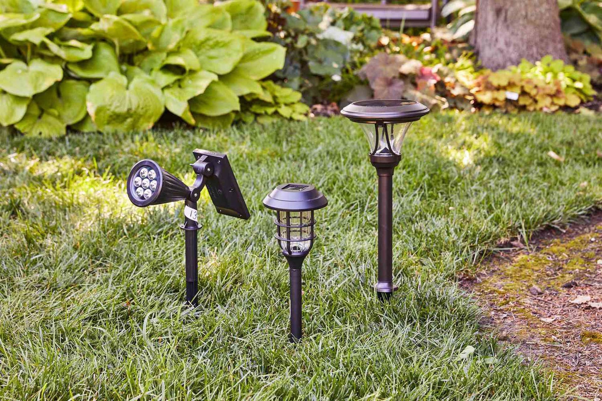 Three different types of lights are sitting in the grass