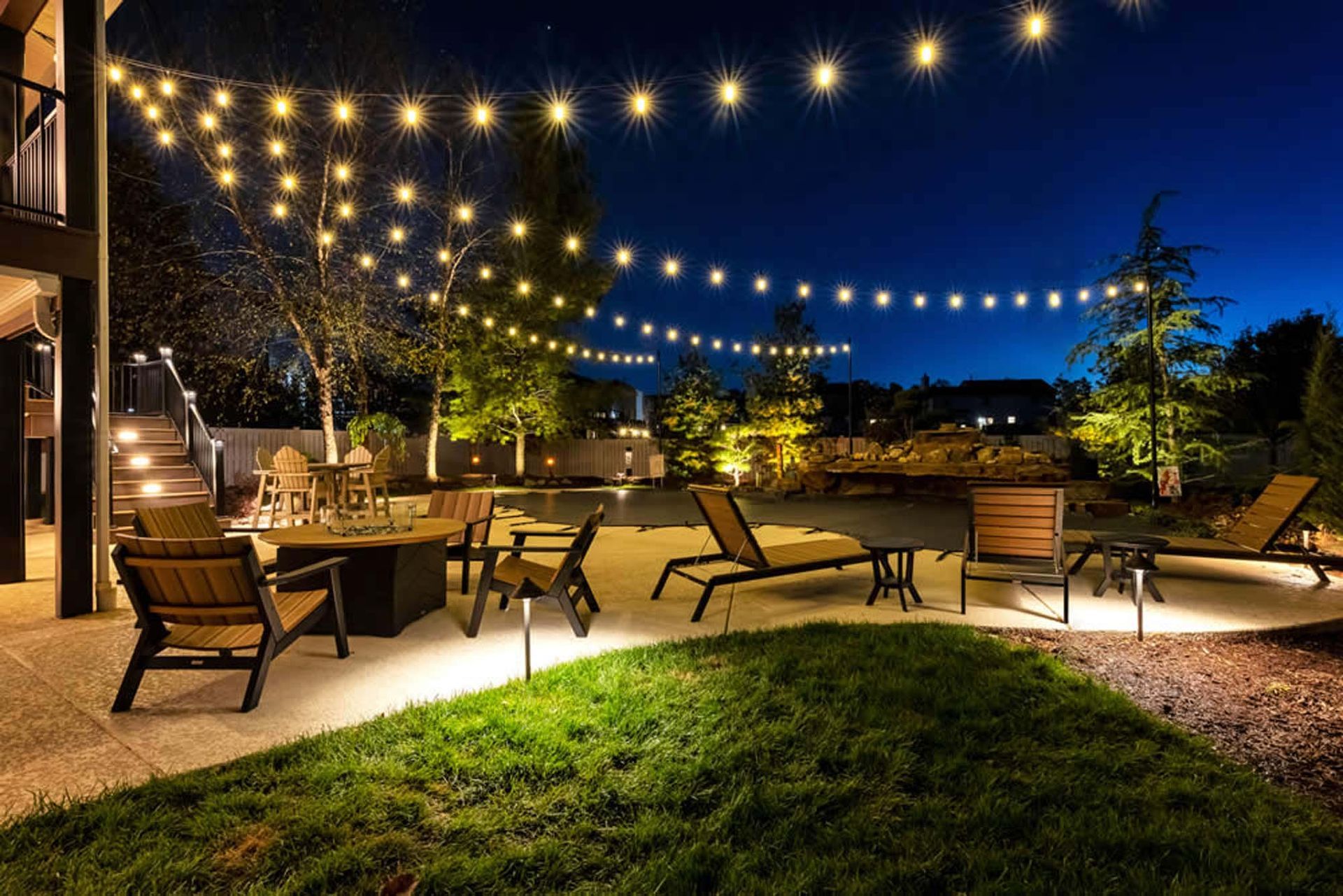 A string of lights hangs over a patio at night