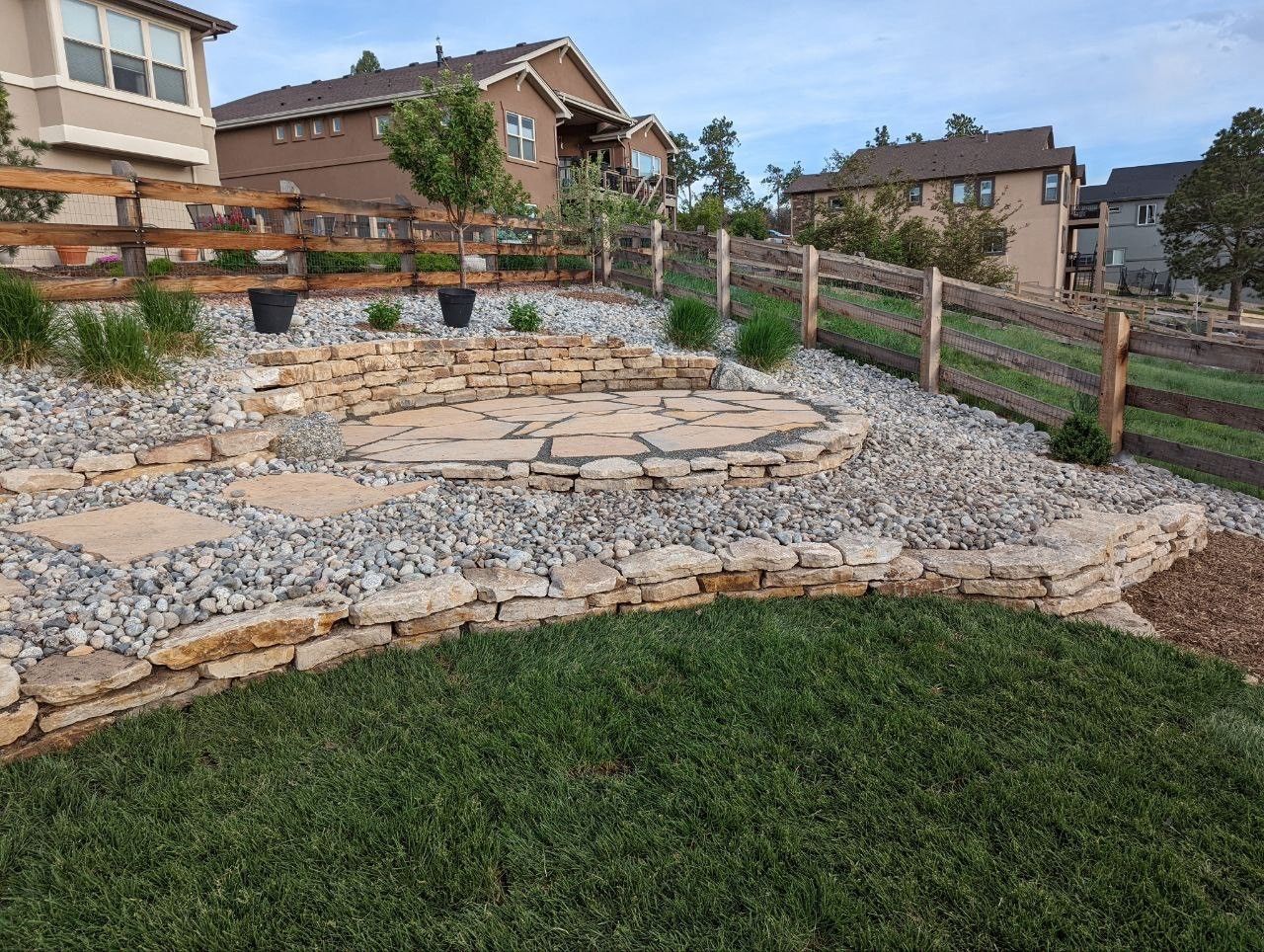 A backyard with a wooden fence and a stone walkway.