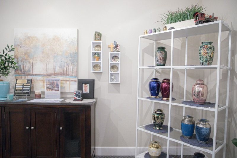 A room with a shelf filled with vases and urns.