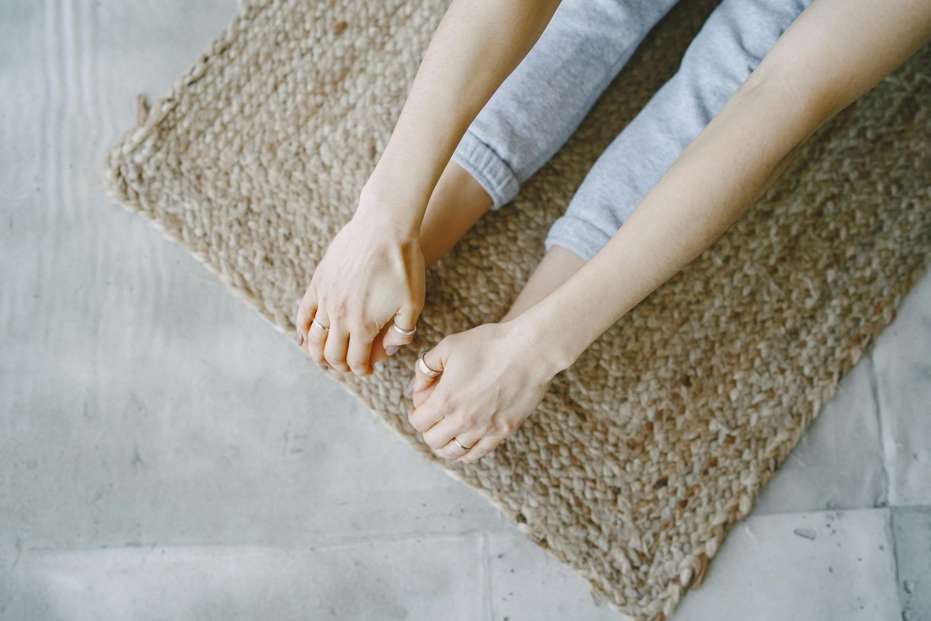 A woman is stretching her legs on a yoga mat.