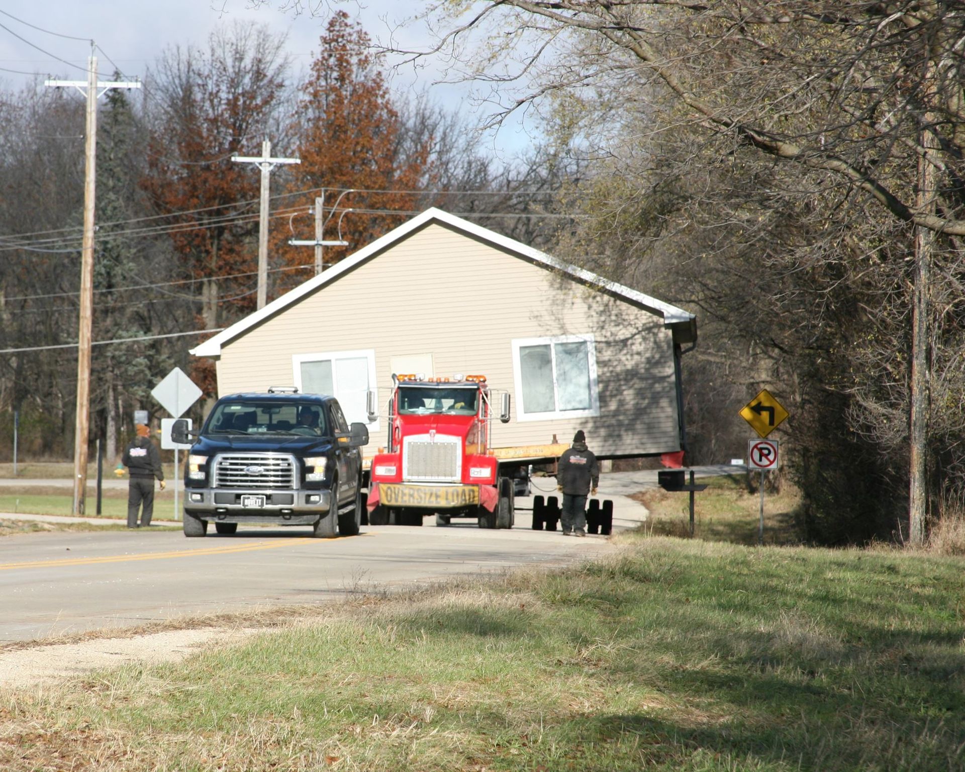 Truck and fire engine blocking a road beside a tan house in a rural area