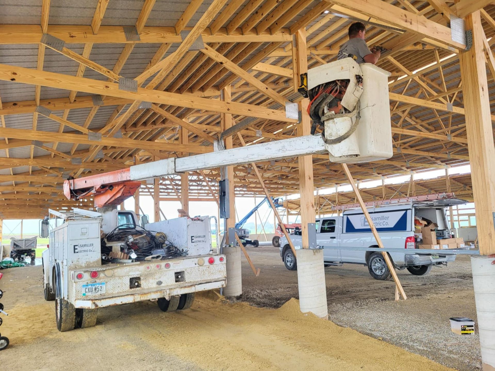 Workers installing HVAC equipment in a wooden building frame under construction