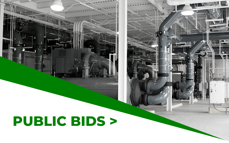 Industrial facility with green banner reading “PUBLIC BIDS >”