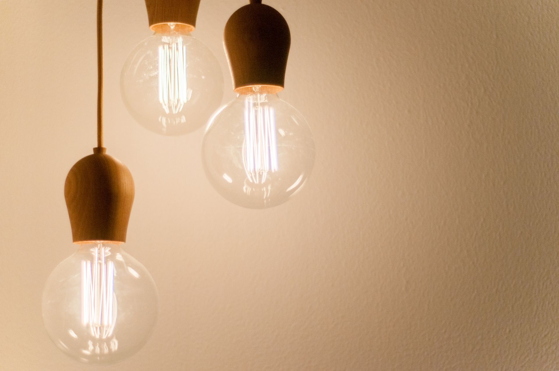 Three light bulbs are hanging from a ceiling in a room.
