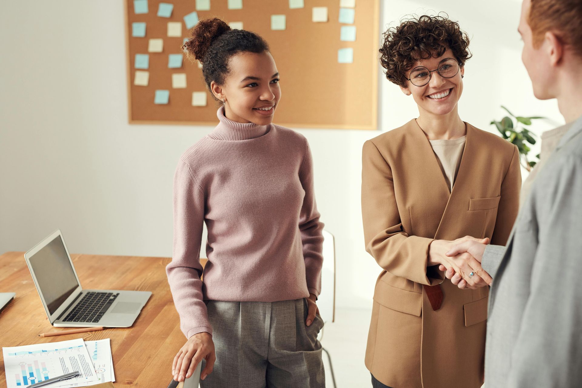 Un groupe de femmes se serrent la main dans un bureau.