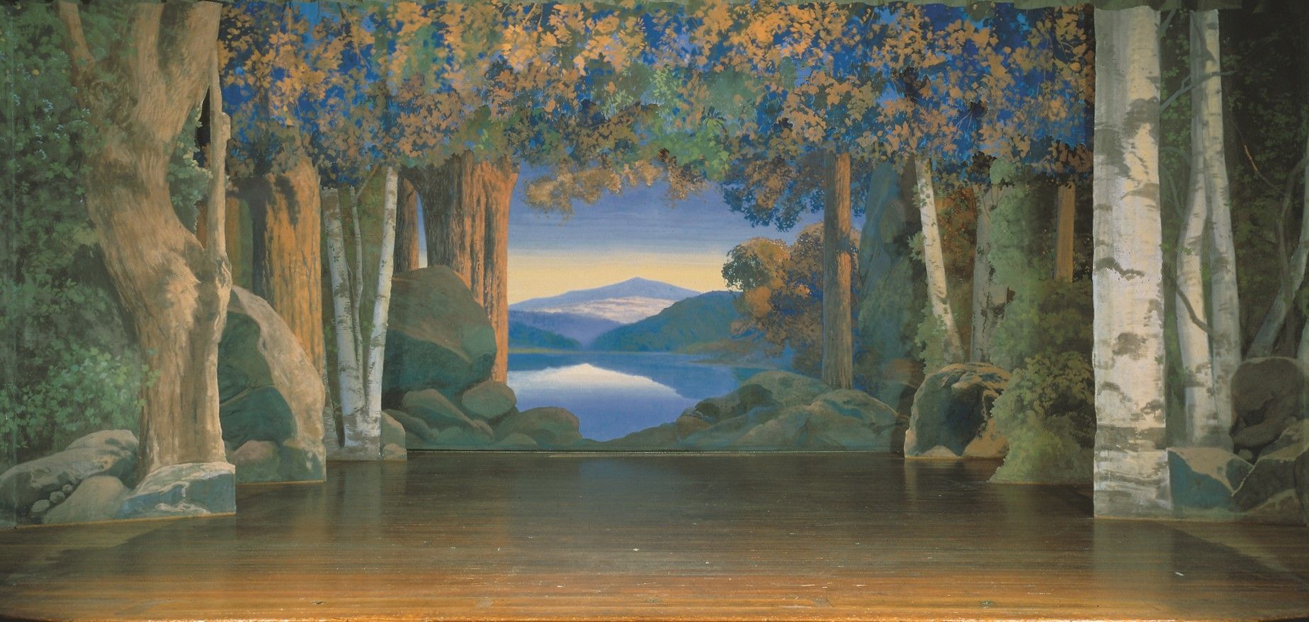 A stage with a painting of trees and a lake in the background