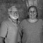 A man and a woman are standing next to each other in a black and white photo.